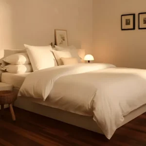 A neatly made bed with LETTO’s Woodland Percale Pillowcase Set in a softly lit bedroom, featuring wooden floors and framed artwork. The temperature-regulating percale fabric keeps you comfortable all night.
